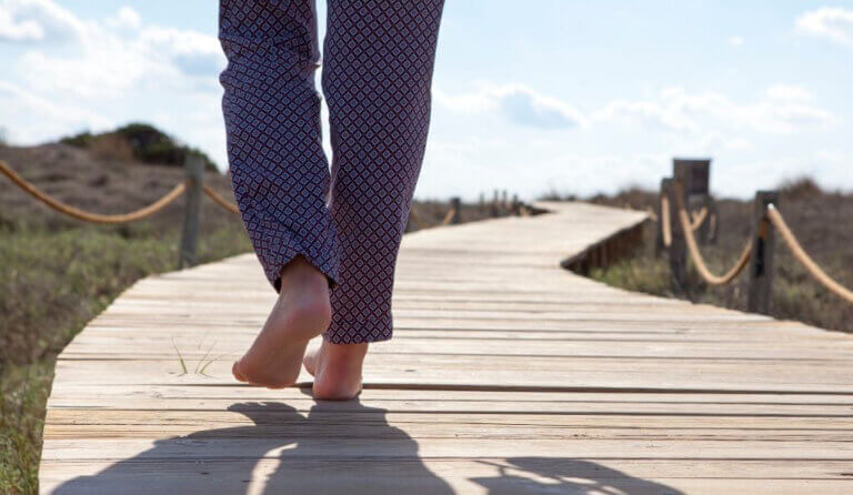 Walking barefoot outside on a boardwalk